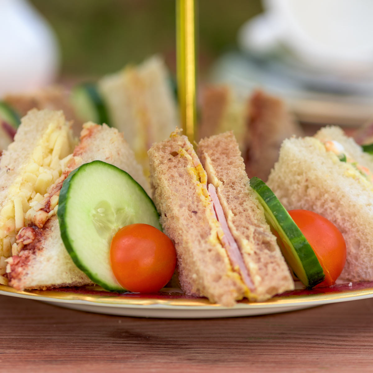 Barnsdale Afternoon Tea. Close up of dainty sandwiches, with cucumber and tomato garnish.
