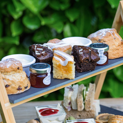 Barnsdale Afternoon Tea from The Helenium Tea Room at Barnsdale Gardens. Two-tiered cake stand with assorted pastries and sandwiches