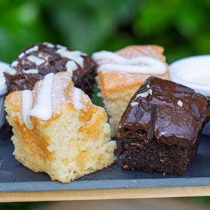 Barnsdale Afternoon Tea from The Helenium Tea Room at Barnsdale Gardens. Assorted small cakes with different toppings on a slate board.