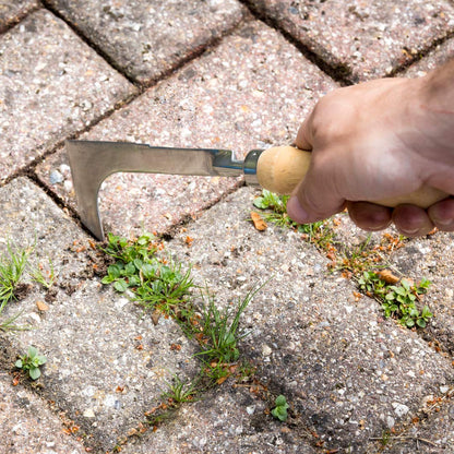 Block paving knife weeding tool. Removing weeds between block paving paviours.