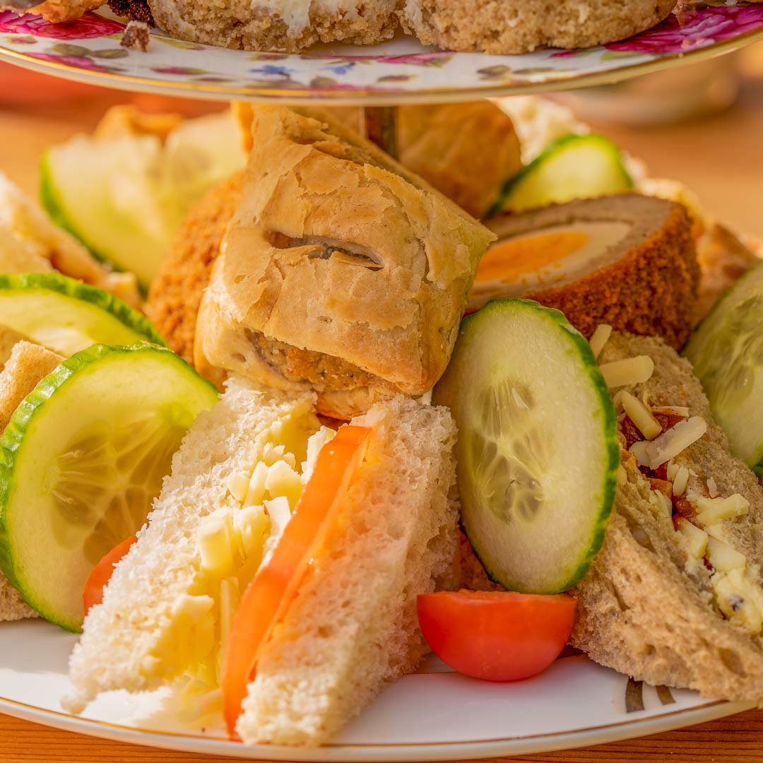 A selection of freshly made dainty sandwiches: Egg mayonnaise & cress; Cucumber & cream cheese; Ham & mustard; Chicken & bacon in honey mustard mayonnaise. Savouries: Sausage roll and scotch egg